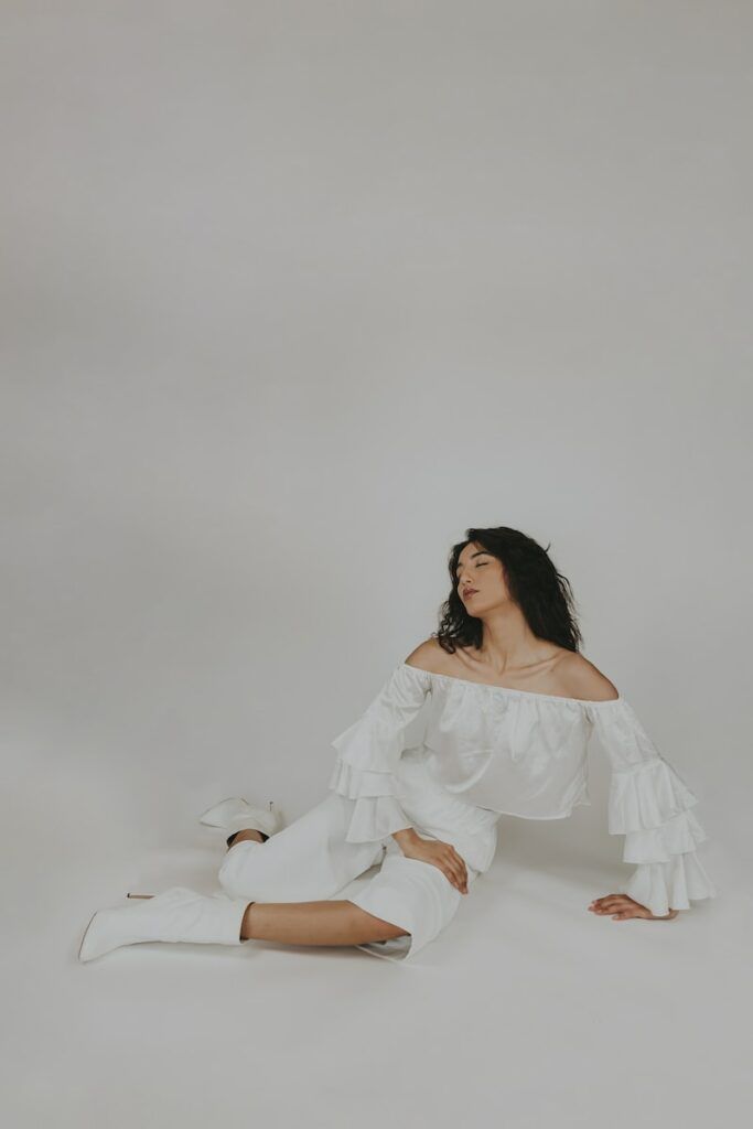 woman in white dress sitting on white floor